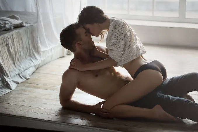 Woman lying on a man on the ground in an intimate manner before they get into the best position for anal sex